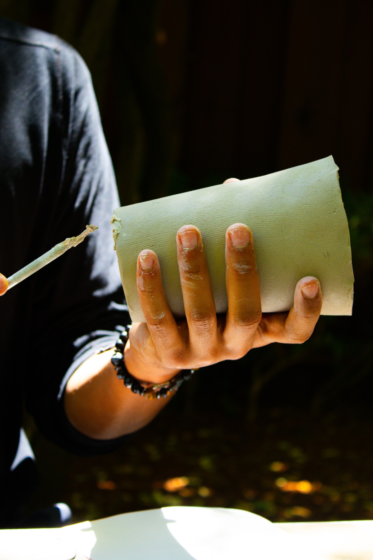 Hand shaping a slab of clay in the studio