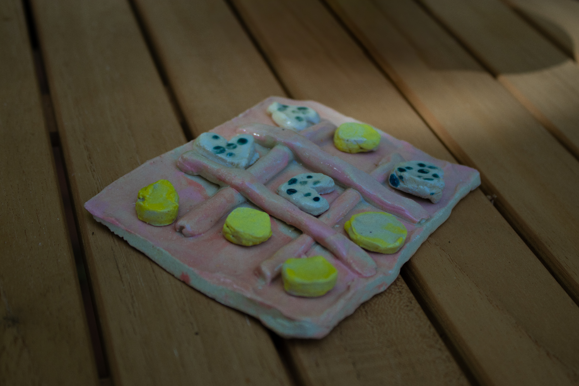 Colorful clay work with shapes on pink base